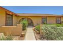 Inviting home exterior featuring a beautiful arched entryway and well-manicured landscaping at 1950 Abarth St, Las Vegas, NV 89142