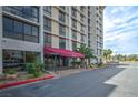Building entrance with a red awning, manicured landscaping, and a seating area at 3930 University Center Dr # 706, Las Vegas, NV 89119