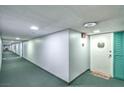 Carpeted hallway with neutral walls, updated lighting, and unit doors at 3930 University Center Dr # 706, Las Vegas, NV 89119