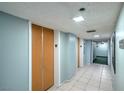 Hallway showing closet doors, tile flooring, and exit signs for safety at 3930 University Center Dr # 706, Las Vegas, NV 89119