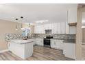 Modern kitchen with white cabinets, granite countertops, stainless appliances, and hardwood floors at 4301 San Joaquin Ave, Las Vegas, NV 89102