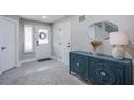 Inviting foyer with a stylish blue cabinet, decorative mirror, and neutral-toned rug at 6630 Virtuoso Ct, Las Vegas, NV 89139