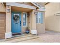 Charming front entrance with a blue door, seasonal wreath, and decorative potted plants at 6630 Virtuoso Ct, Las Vegas, NV 89139