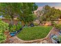 Lush backyard featuring a well-maintained lawn, mature trees, and manicured garden beds at 7252 Royal Melbourne Dr, Las Vegas, NV 89131