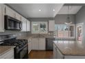 Bright kitchen features granite counters, white cabinets, and modern stainless steel appliances at 7500 Sea Spray Ave, Las Vegas, NV 89128