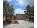 Inviting single-story home with a well-manicured front yard and mature trees at 9329 Fresh Spring Dr, Las Vegas, NV 89134