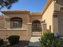 Inviting front entrance with a decorative gate, a window with an awning, and low-maintenance landscaping at 9329 Fresh Spring Dr, Las Vegas, NV 89134