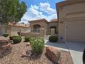 Well-maintained front yard with decorative rock landscaping and mature trees at 9329 Fresh Spring Dr, Las Vegas, NV 89134
