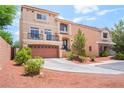 Two-story tan stucco home with a balcony, attached garage, and desert landscaping at 9704 Morgan Creek Ct, Las Vegas, NV 89141