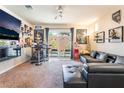 Carpeted living room featuring a bar, media center, and outdoor access at 9704 Morgan Creek Ct, Las Vegas, NV 89141