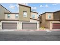 Three modern townhomes each featuring two-car garages and contemporary architectural design under a blue sky at 9929 Bumblebee Hills St, Las Vegas, NV 89141