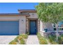 Close-up of a modern home featuring a stylish blue front door with stone accents and lush landscaping at , Las Vegas, NV 89148