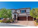 Attractive two-story home featuring a three-car garage, brick accents, and tasteful landscaping at 10420 Loma Portal Ave, Las Vegas, NV 89166