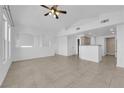 Spacious living room featuring tile flooring, an open floorplan, and a ceiling fan in a neutral color palette at 10550 W Alexander Rd # 2079, Las Vegas, NV 89129