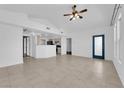 Bright and airy living room with tile flooring, ceiling fan, and view into open kitchen in neutral color palette at 10550 W Alexander Rd # 2079, Las Vegas, NV 89129