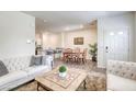 Open concept living and dining area with modern decor, hardwood floors, and view of the kitchen at 12728 Feathersong St, Henderson, NV 89044