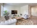 Comfortable living room featuring neutral paint, plush couches, stylish rug, and a large window at 12728 Feathersong St, Henderson, NV 89044