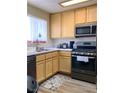 Well-lit kitchen featuring modern stainless steel appliances and light wood cabinets at 1533 Linnbaker Ln # 102, Las Vegas, NV 89110
