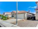 Exterior showcases a well-maintained home, two-car garage, desert landscaping, and tiled roof at 1829 Fighting Falcon Ln, North Las Vegas, NV 89031