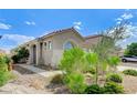 Beautiful home exterior featuring desert landscaping, complemented by an arched window at 1829 Fighting Falcon Ln, North Las Vegas, NV 89031