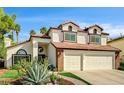 Inviting two-story home featuring a two-car garage and lush desert landscaping at 2036 Deer Springs Dr, Henderson, NV 89074