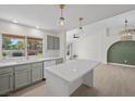 Open-concept kitchen with stainless steel appliances, quartz countertops, island, and seamless flow to living area at 2216 Spring Water Dr, Las Vegas, NV 89134