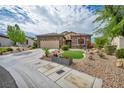 Inviting single-story home featuring stone accents, a two-car garage, and desert landscaping at 2621 Icy Moon St, Henderson, NV 89044