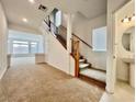 Bright living room with plush carpet, staircase, and large windows filling the space with natural light at 5709 Woodchester Ave, Las Vegas, NV 89139