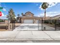 Street view of a two-story home with desert landscaping, a three-car garage, and a gated entrance at 6101 Browning Way, Las Vegas, NV 89130