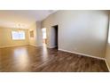 Bright and open-concept living area with hardwood flooring and a view of the dining area and kitchen at 6516 Velvet Silk St, North Las Vegas, NV 89084