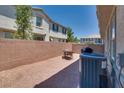 Private backyard area with a brick wall, patio furniture, and gravel landscaping at 9112 Canoga Canyon Ct # 103, Las Vegas, NV 89149