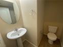 This powder room features a pedestal sink, a toilet, tile floors, and neutral paint at 10537 Thor Mountain Ln, Las Vegas, NV 89166