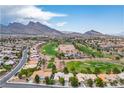 Stunning aerial view of a neighborhood with lush golf course and mountain backdrop, offering picturesque scenery at 10646 Heritage Hills Dr, Las Vegas, NV 89134