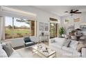 Bright, virtually staged living room with large windows offering golf course views and contemporary furnishings at 10646 Heritage Hills Dr, Las Vegas, NV 89134