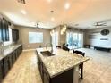 Beautiful kitchen with a large island, granite counters, and open layout to the living area at 10719 Hammett Park Ave, Las Vegas, NV 89166