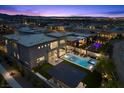 Aerial view of a modern home with a private pool, spa, and outdoor entertaining area at twilight at 12637 Penfield Ave, Las Vegas, NV 89138