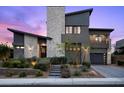 Modern home exterior showcases stone accents, a two-car garage, and manicured landscaping at 12637 Penfield Ave, Las Vegas, NV 89138