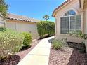 A quaint walkway leads to a charming home, surrounded by lush greenery and well-maintained landscaping at 2119 Sunset Vista Ave, Henderson, NV 89052