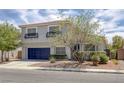Inviting two-story home with desert landscaping, a blue garage door, and decorative window awnings at 2367 Tilden Way, Henderson, NV 89074