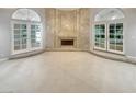 Spacious room with marble fireplace, carpeted floors and French doors letting in ample natural light at 3957 Placita Del Lazo, Las Vegas, NV 89120