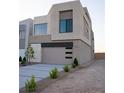 Modern two-story home featuring a two-car garage, clean lines, and desert landscaping at 3980 Heron Fairway Dr, Las Vegas, NV 89141