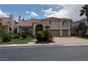Beautiful two-story home with a three-car garage, arched entryway, and meticulously maintained front yard at 4139 Abernethy Forest Pl, Las Vegas, NV 89141