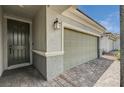 Close-up view of a home's entrance, highlighting the front door, garage, and stone-paved driveway at 4293 Nopal Serrano Ave, Las Vegas, NV 89141