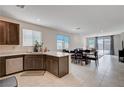 Open-concept kitchen and living area with modern appliances, tile flooring, and ample natural light at 4293 Nopal Serrano Ave, Las Vegas, NV 89141