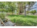 Lush backyard with mature trees, green grass, and seating for outdoor enjoyment at 4998 Schumann Dr, Las Vegas, NV 89146