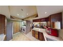 Cozy kitchen with laundry area featuring updated appliances, tile floors and stone counters at 4998 Schumann Dr, Las Vegas, NV 89146