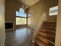 Bright living room with a fireplace and large windows overlooking palm trees at 5128 Sandstone Dr, Las Vegas, NV 89142