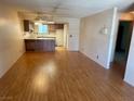 Open-concept living room and kitchen featuring wood-look floors at 5199 Caliente St # 64, Las Vegas, NV 89119