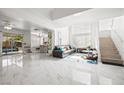 Bright living room with marble floors, open layout, and a staircase to the upper level at 5332 Desert Blossom Rd, Las Vegas, NV 89107