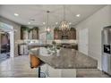 Open kitchen with stainless steel appliances, granite countertops, large island and stylish pendant lights at 5341 Kennedy Hill Ave, Las Vegas, NV 89139